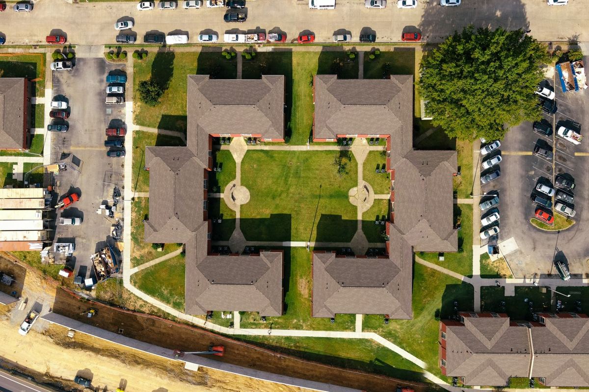 Aerial view of a courtyard apartment building and its parking
