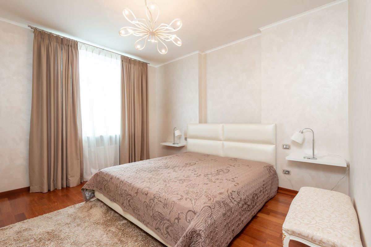 Bedroom with floor-length curtains and bedside reading lamps