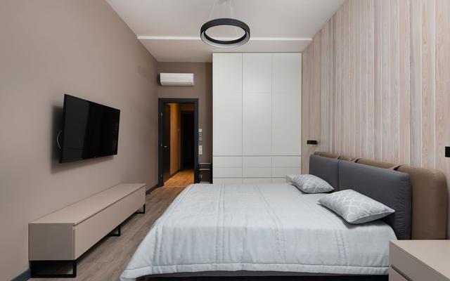 Bedroom with a wall-mounted television and a built-in wardrobe