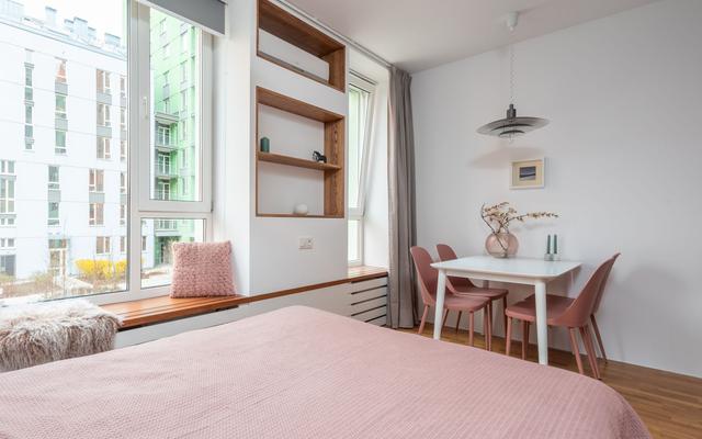 Studio apartment with a bed, a window bench and a small dining table
