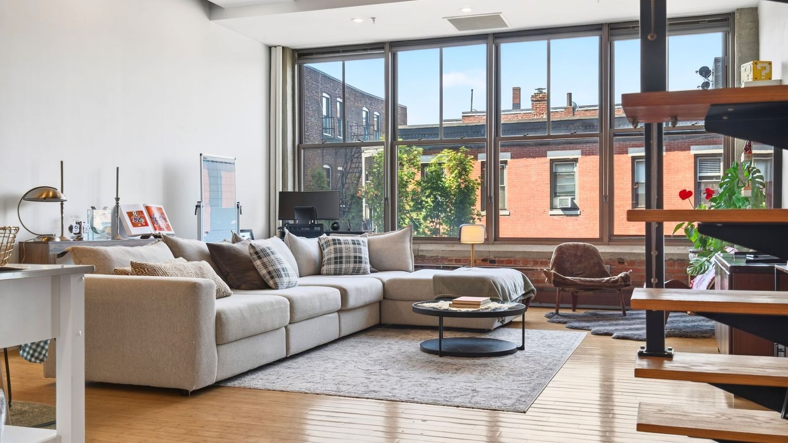 Bright apartment living room with tall windows and a corner sofa