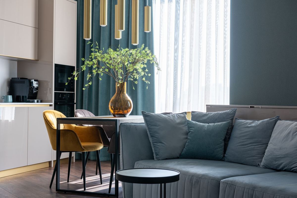 Apartment dining table and sofa beside a curtained window