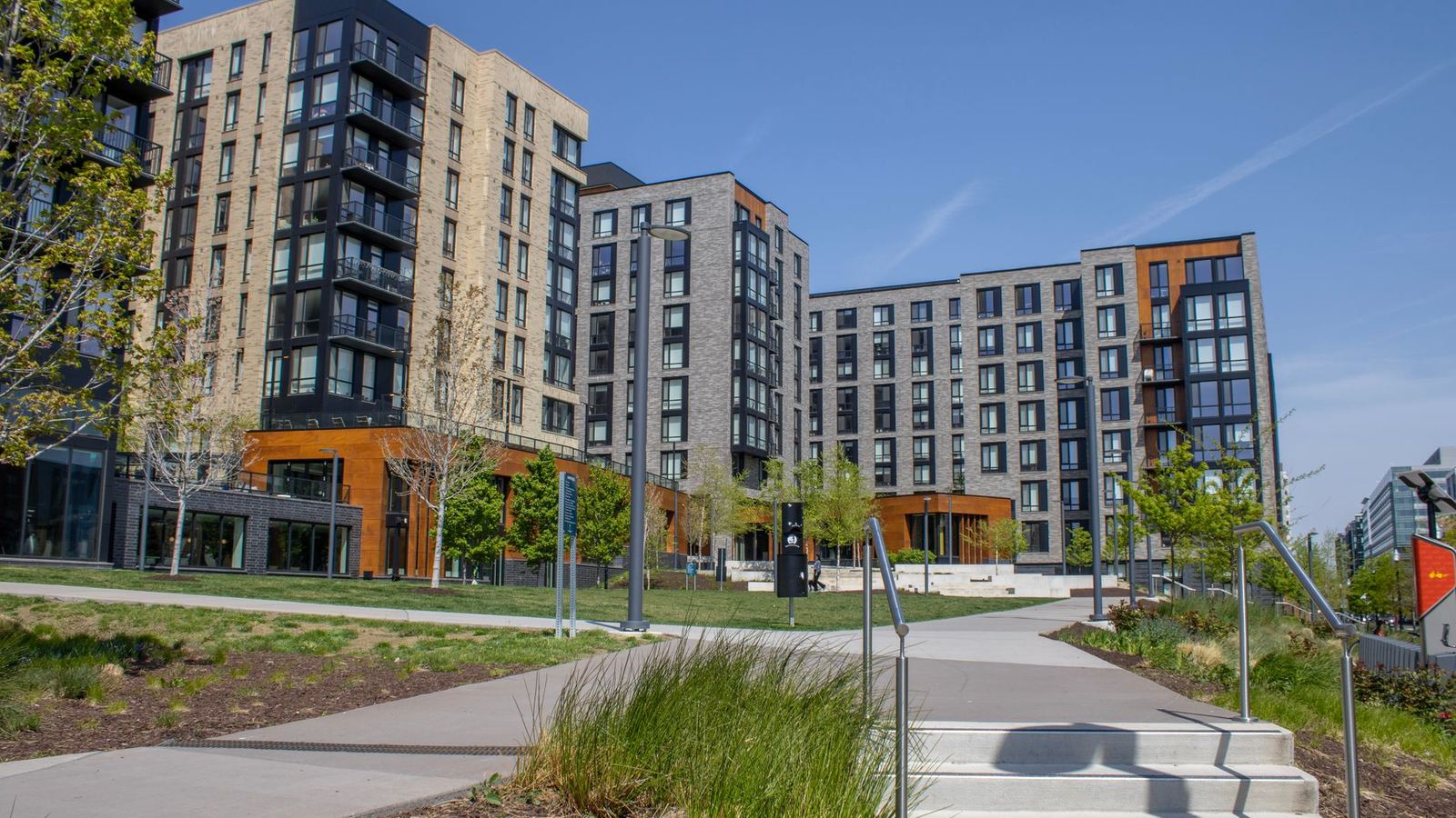 Modern mid-rise apartment buildings along a landscaped path