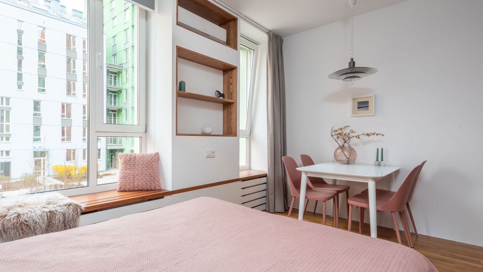 Studio apartment with a bed, a window bench and a small dining table