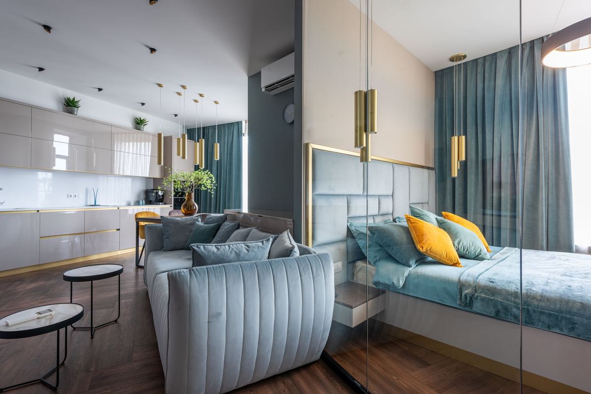 Studio apartment with a sofa and a glass-partitioned sleeping area